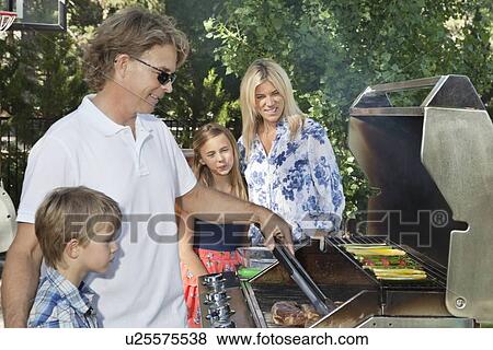 Family of four barbecuing View Large Photo Image Stock Photo - Family of four barbecuing. Fotosearch