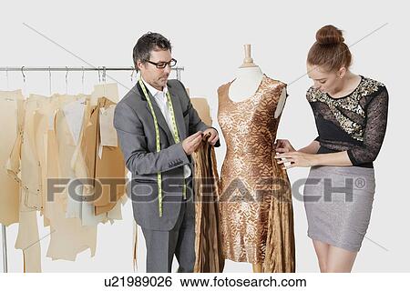 Fashion designers working together on an outfit in design studio View Large Photo Image Stock Photograph - Fashion designers working together on an outfit in design studio. Fotosearch