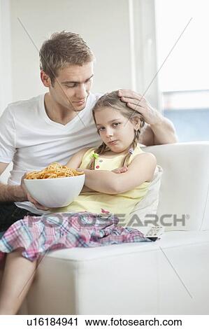 Father convincing daughter to eat wheel shape snack pellets View Large Photo Image Stock Image - Father convincing daughter to eat wheel shape snack pellets. Fotosearch