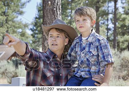 Stock Photo - Father pointing out at something to his son in park. Fotosearch