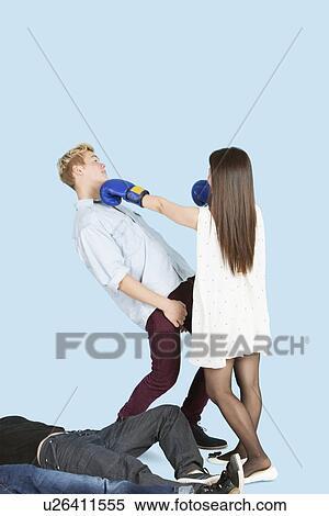 Stock Photography - Female boxer punching man with people lying in foreground. Fotosearch