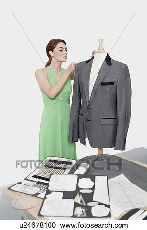 Female designer adjusting coat on tailor's dummy over gray background View Large Photo Image Stock Image - Female designer adjusting coat on tailor's dummy over gray background. Fotosearch