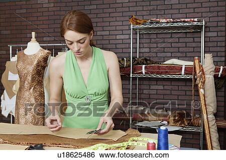 Stock Photograph - Female fashion designer working in design studio. Fotosearch