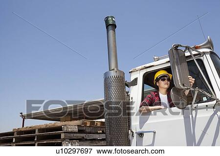 Female industrial worker adjusting mirror while sitting in logging truck View Large Photo Image Stock Photo - Female industrial worker adjusting mirror while sitting in logging truck. Fotosearch