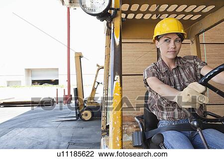 Female industrial worker driving forklift truck View Large Photo Image Stock Image - Female industrial worker driving forklift truck. Fotosearch