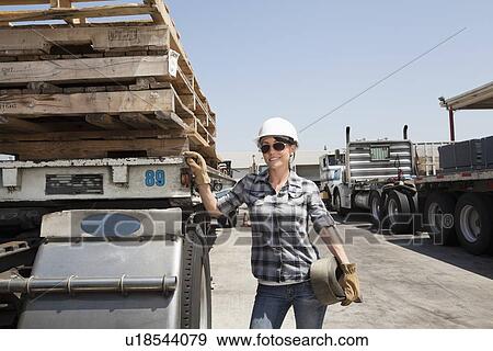 Female industrial worker standing by flatbed truck in timber yard View Large Photo Image Stock Photo - Female industrial worker standing by flatbed truck in timber yard. Fotosearch