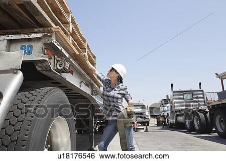 Female industrial worker strapping down wooden planks on logging truck View Large Photo Image Stock Photograph - Female industrial worker strapping down wooden planks on logging truck. Fotosearch