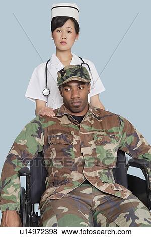 Female nurse comforting disabled US Marine Corps soldier in wheelchair over light blue background View Large Photo Image Stock Photo - Female nurse comforting disabled US Marine Corps soldier in wheelchair over light blue background. Fotosearch