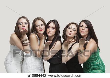 Stock Image - Five young women blowing kisses over gray background. Fotosearch