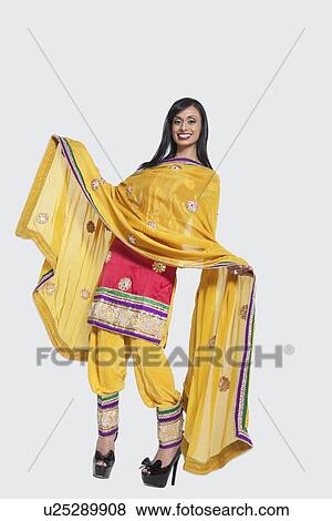 Full length of an Indian woman in salwar kameez standing over gray background View Large Photo Image Stock Photo - Full length of an Indian woman in salwar kameez standing over gray background. Fotosearch