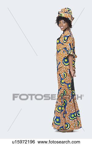 Full length portrait of young woman in African print attire standing over gray background View Large Photo Image Stock Photograph - Full length portrait of young woman in African print attire standing over gray background. Fotosearch