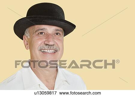 Happy senior man wearing hat while looking up over yellow background View Large Photo Image Stock Photo - Happy senior man wearing hat while looking up over yellow background. Fotosearch