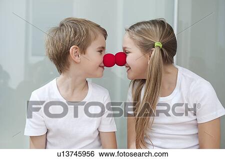 Happy young siblings in white tshirts rubbing clown noses against each other View Large Photo Image Stock Photograph - Happy young siblings in white tshirts rubbing clown noses against each other. Fotosearch
