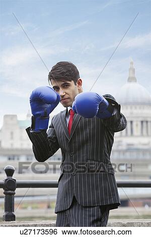 Indian businessman wearing blue boxing gloves with St. Paul's Cathedral in the background View Large Photo Image Stock Photograph - Indian businessman wearing blue boxing gloves with St. Paul's Cathedral in the background. Fotosearch