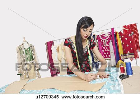 Stock Photography - Indian female clothing designer working in design studio. Fotosearch