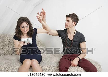 Stock Image - Irritated young man with woman playing video game. Fotosearch