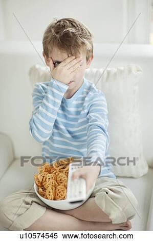 Little boy watching scary movie with a bowl full of wheel shape snack pellets View Large Photo Image Stock Photography - Little boy watching scary movie with a bowl full of wheel shape snack pellets. Fotosearch