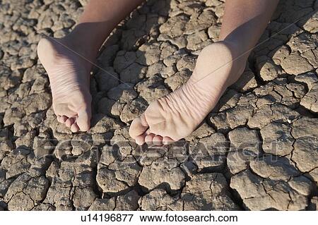 Low section of a woman lying on cracked land View Large Photo Image Stock Photo - Low section of a woman lying on cracked land. Fotosearch