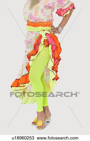 Stock Image - Low section of woman in Brazilian outfit with hand on hip over gray background. Fotosearch