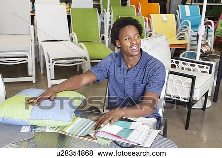 Male African American salesperson working in garden furniture store View Large Photo Image Stock Photo - Male African American salesperson working in garden furniture store. Fotosearch