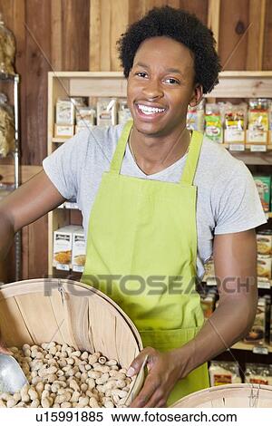 Male African American store clerk holding basket of peanuts View Large Photo Image Stock Photography - Male African American store clerk holding basket of peanuts. Fotosearch