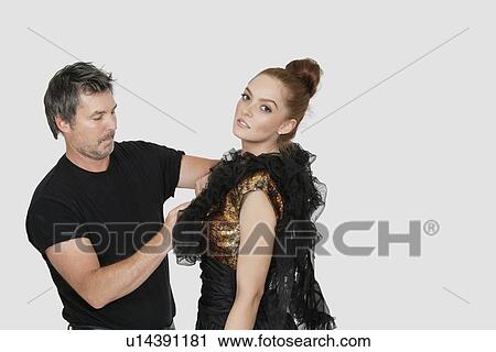 Male fashion designer adjusting dress on model over colored background View Large Photo Image Stock Image - Male fashion designer adjusting dress on model over colored background. Fotosearch