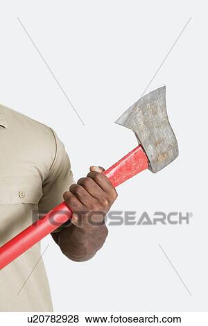 Male hand holding axe over gray background View Large Photo Image Stock Photo - Male hand holding axe over gray background. Fotosearch