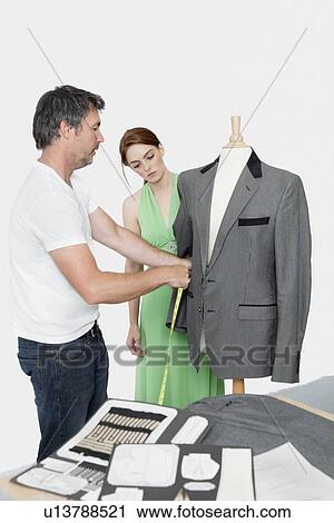 Male tailor taking measurement of suit while female coworker standing besides View Large Photo Image Stock Image - Male tailor taking measurement of suit while female coworker standing besides. Fotosearch
