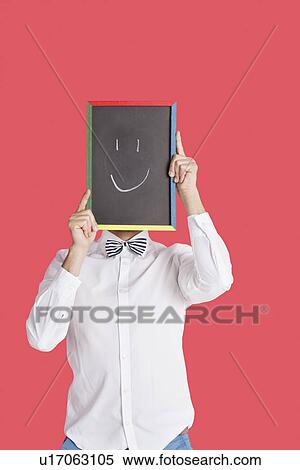 Man holding smiley face sign over red background View Large Photo Image Stock Photography - Man holding smiley face sign over red background. Fotosearch