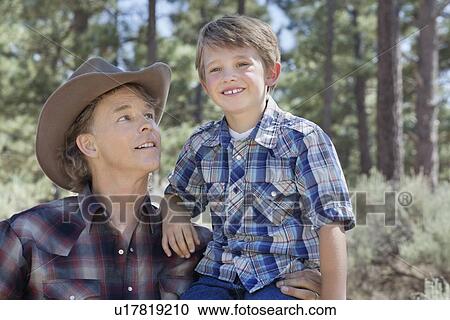 Stock Image - Mature father looking at son in the park. Fotosearch