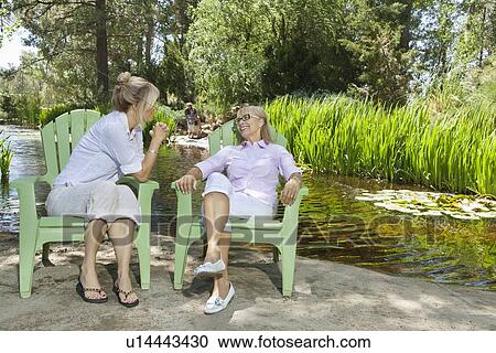 Mature woman and mother relaxing with man and child fishing in the background View Large Photo Image Stock Image - Mature woman and mother relaxing with man and child fishing in the background. Fotosearch