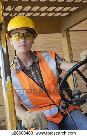 Mid adult female industrial worker driving forklift truck View Large Photo Image Stock Image - Mid adult female industrial worker driving forklift truck. Fotosearch