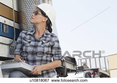 Mid adult woman inspecting timber truck View Large Photo Image Stock Photo - Mid adult woman inspecting timber truck. Fotosearch