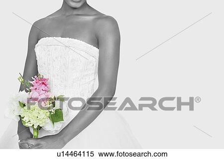 Midsection of bride holding bouquet over gray background View Large Photo Image Stock Photography - Midsection of bride holding bouquet over gray background. Fotosearch