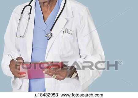 Midsection of male doctor writing on clipboard over light blue background View Large Photo Image Stock Image - Midsection of male doctor writing on clipboard over light blue background. Fotosearch