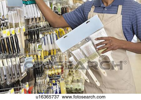Midsection of male store clerk holding painting tools View Large Photo Image Stock Photo - Midsection of male store clerk holding painting tools. Fotosearch