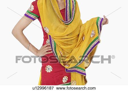 Stock Photo - Midsection of woman in traditional wear standing with hand on hip over white background. Fotosearch