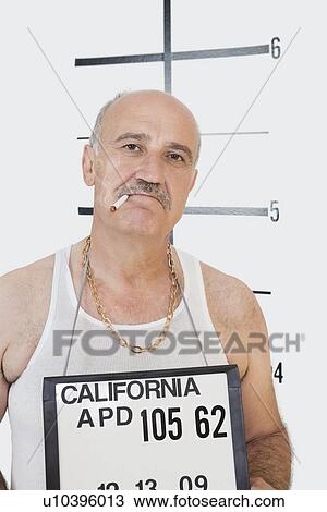 Stock Image - Mug shot of senior gangster smoking cigarette. Fotosearch