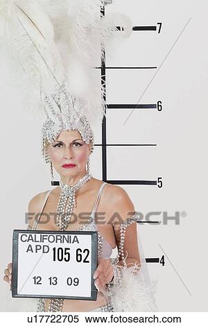 Stock Photography - Mug shot of senior showgirl holding plaque. Fotosearch