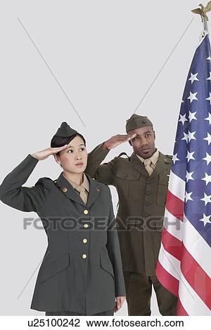 Stock Image - Multi-ethnic US military officers saluting American flag over gray background. Fotosearch