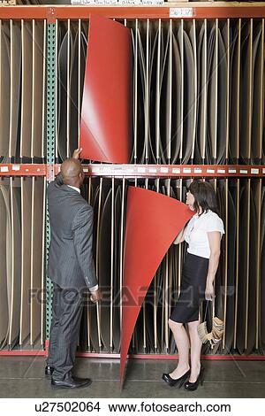 Multiethnic business colleagues selecting thin red veneer sheets View Large Photo Image Picture - Multiethnic business colleagues selecting thin red veneer sheets. Fotosearch