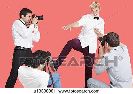 Paparazzi taking photographs of male actor over red background View Large Photo Image Stock Image - Paparazzi taking photographs of male actor over red background. Fotosearch