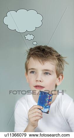 Pensive little boy holding credit card with speech bubble over gray background View Large Photo Image Stock Photo - Pensive little boy holding credit card with speech bubble over gray background. Fotosearch