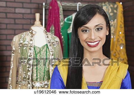 Portrait of a beautiful Indian female dressmaker smiling View Large Photo Image Stock Photograph - Portrait of a beautiful Indian female dressmaker smiling. Fotosearch