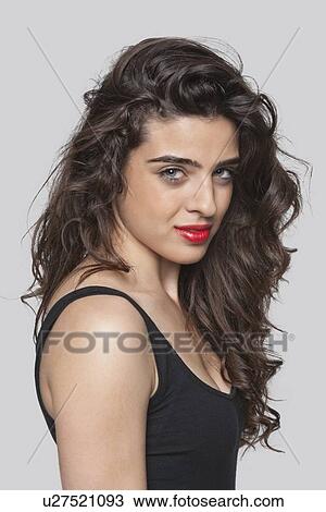 Portrait of a beautiful young woman against gray background View Large Photo Image Stock Image - Portrait of a beautiful young woman against gray background. Fotosearch