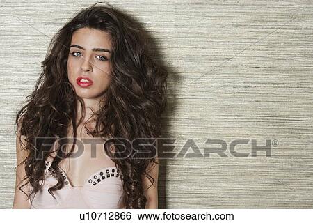 Portrait of a beautiful young woman against textured background View Large Photo Image Stock Photograph - Portrait of a beautiful young woman against textured background. Fotosearch