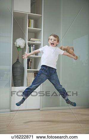 Portrait of a boy in casuals jumping in mid-air View Large Photo Image Stock Image - Portrait of a boy in casuals jumping in mid-air. Fotosearch