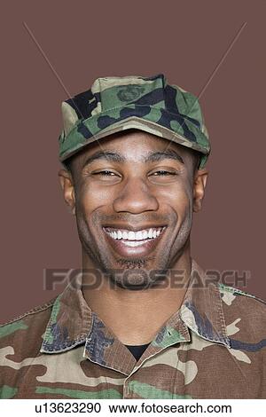 Stock Image - Portrait of a cheerful young African American US Marine Corps soldier over brown background. Fotosearch