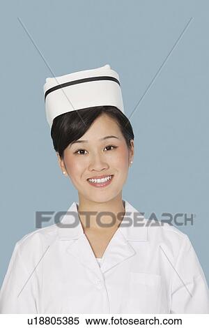 Stock Photography - Portrait of a happy pretty doctor over light blue background. Fotosearch