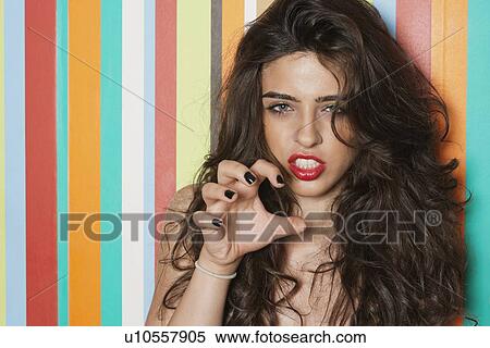 Portrait of a sensuous young woman gesturing against colorful striped background View Large Photo Image Stock Photography - Portrait of a sensuous young woman gesturing against colorful striped background. Fotosearch